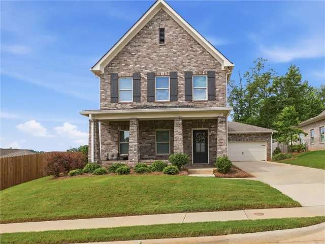 A classic brick facade and inviting front porch define this charming suburban residence.