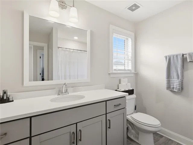 A well-appointed bath features a sleek vanity, generous mirror, and convenient window.