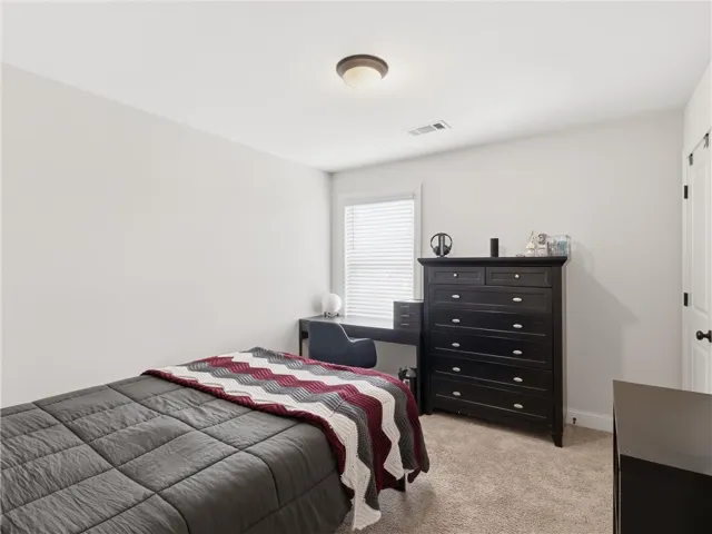 Well-lit sleeping quarters with plush carpeting, room for a work station