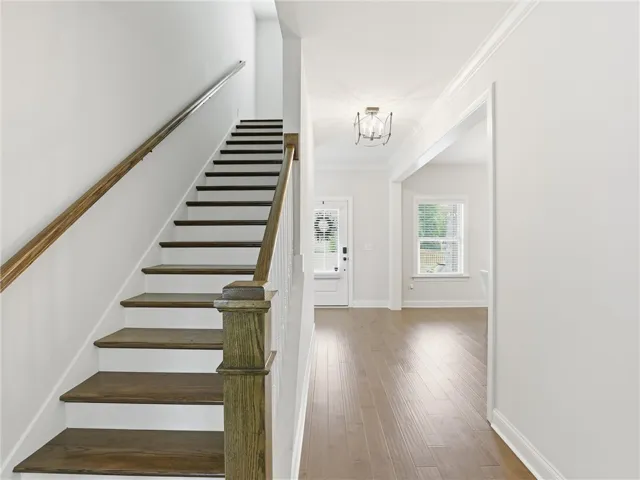 Grand entryway with rich hardwood floors and a striking staircase welcomes you home.