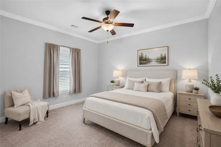 Relaxation awaits in this inviting bedroom, featuring a classic ceiling fan and plush carpeting. Virtually staged