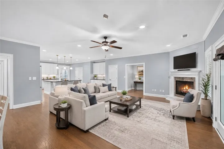 An inviting gathering space features warm wood flooring and a cozy fireplace, perfect for relaxation. Virtually staged