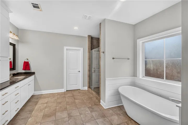 A well-appointed bath offers a sleek soaking tub and a spacious walk-in shower.