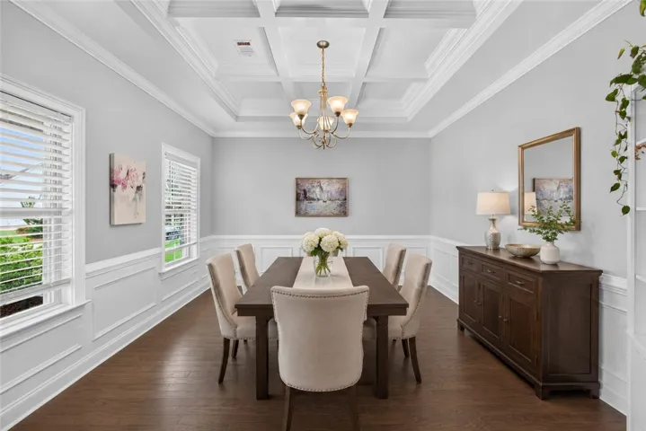 Elegant coffered ceilings crown this refined dining space, perfect for entertaining. Virtually staged