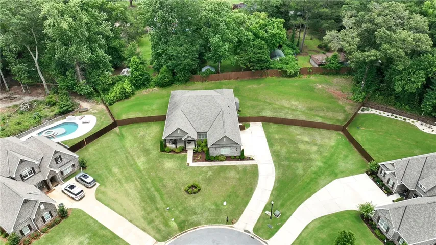 Discover a private oasis featuring a refreshing pool and an expansive green yard, perfect for relaxation and recreation.