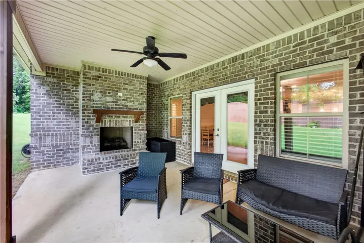 A spacious covered patio invites relaxation, featuring a cozy fireplace and durable brick construction.