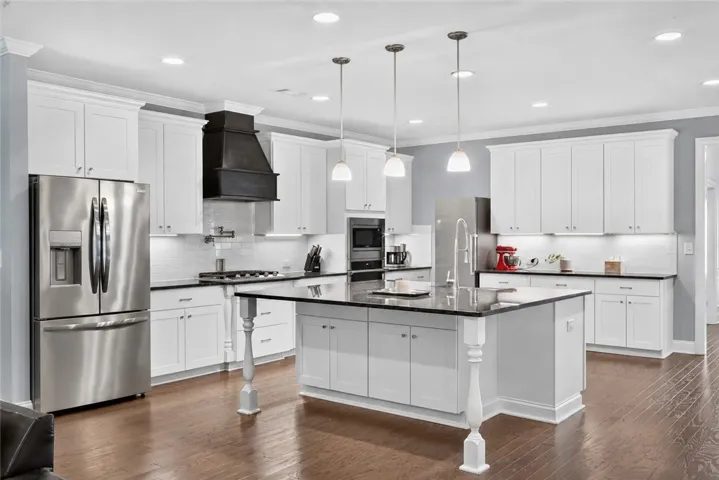 A gourmet kitchen boasts gleaming hardwood floors, granite countertops, and modern stainless steel appliances.
