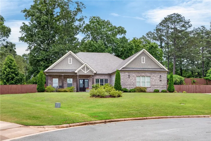 A classic brick exterior with gabled roofs and well-tended landscaping offers a welcoming facade.