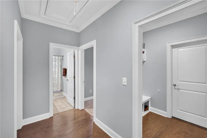 Rich hardwood flooring leads to multiple rooms from this welcoming hallway.