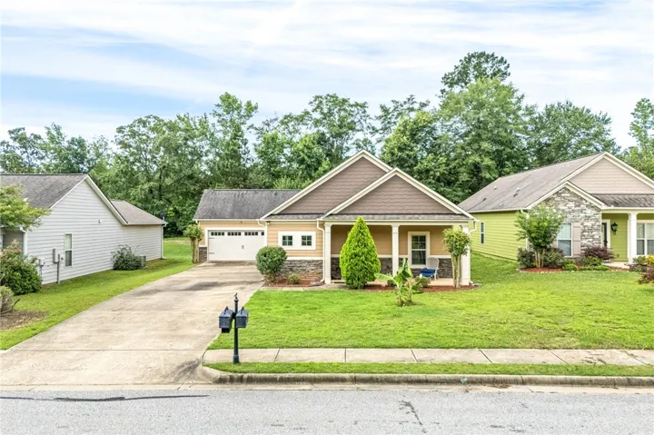 A well-kept front yard and driveway lead to this charming single-story residence with an attached garage.