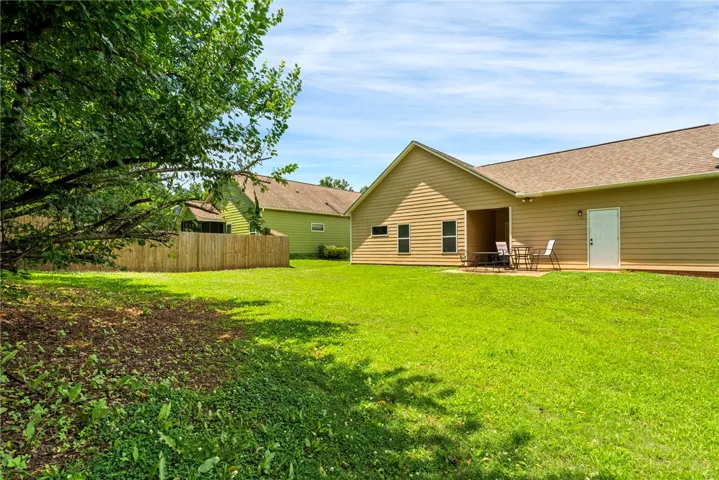 Green yard space with ample room for leisure and outdoor activities, complemented by a private patio.