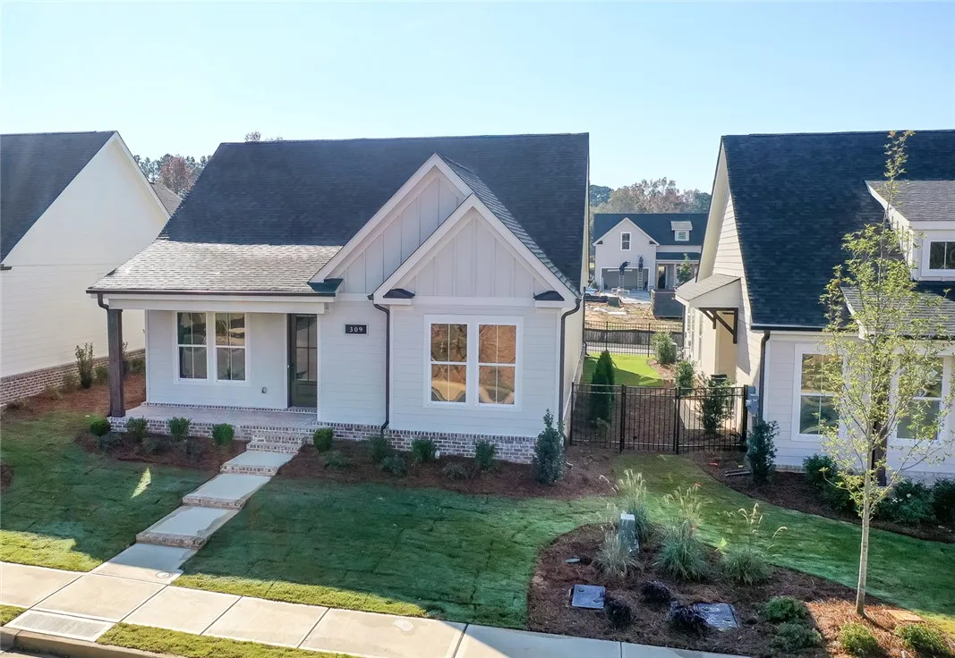 A charming single-story residence boasts a manicured lawn and a welcoming front porch, ready for immediate occupancy. Photos are not of subject property. Photos are of the same floorplan of a completed home.