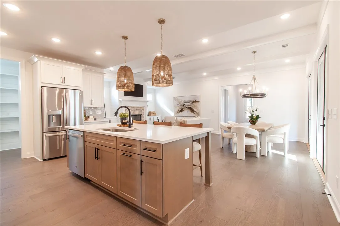 An inviting open-concept layout connects the well-appointed kitchen to a bright dining area and living space. Photos are not of subject property. Photos are of the same floorplan of a completed home.