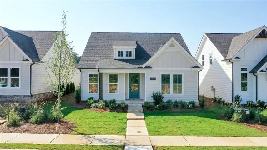 A charming single-family home with inviting curb appeal and a well-maintained lawn. Photos are not of subject property. Photos are of the same floorplan of a completed home.