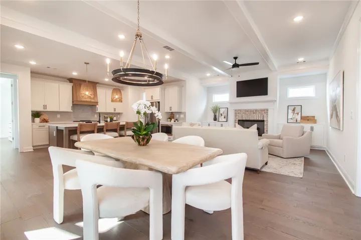An open concept design seamlessly connects the dining area, chef's kitchen, and a cozy living space with a classic fireplace. Photos are not of subject property. Photos are of the same floorplan of a completed home.