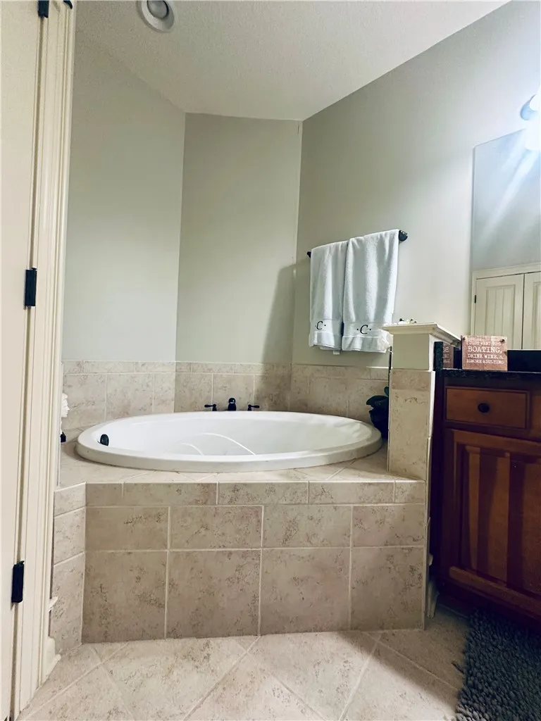 An inviting soaking tub awaits in this thoughtfully tiled bathroom.