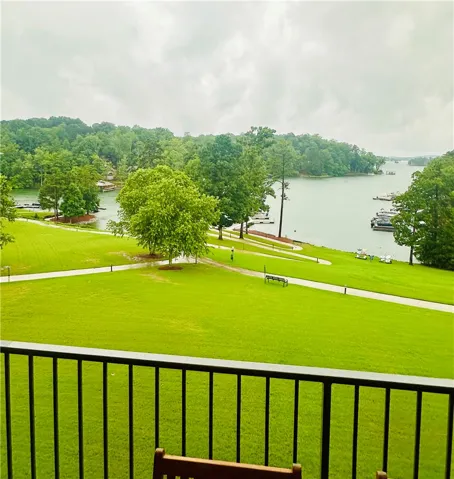 A tranquil lake view awaits from this verdant landscape, featuring lush lawns and distant docks.