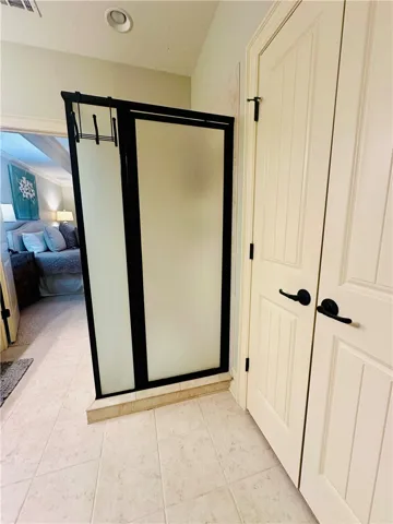 Functional bathroom space featuring a frosted glass shower enclosure and tiled flooring.