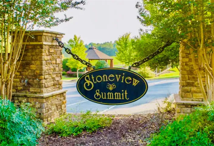 Stone pillars frame the entrance to this charming community, beckoning residents home.