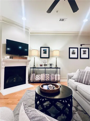 A well-lit living area features a corner fireplace and crown molding, enhancing its inviting atmosphere.
