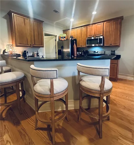 Natural wood cabinets and hardwood flooring elevate this thoughtfully designed kitchen space.