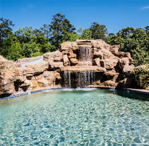 An inviting private pool awaits, complete with a dramatic rock waterfall feature.