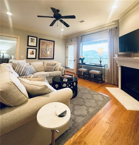 Hardwood floors and a cozy fireplace anchor this inviting living space, offering expansive outdoor views.