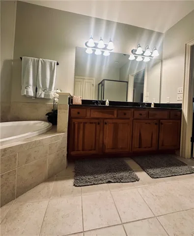 Luxurious bathing quarters feature a deep soaking tub alongside a double vanity, complete with ample storage.