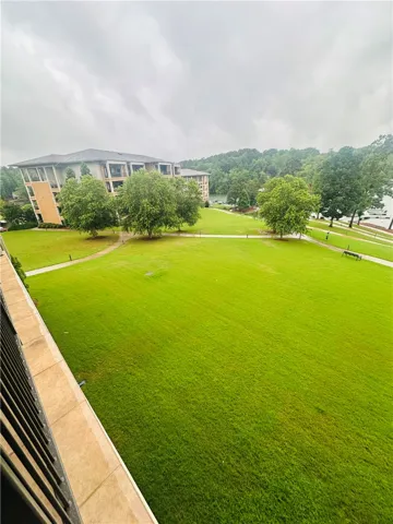 Green grounds stretch to the serene waterfront, framed by a handsome building and lush treeline.