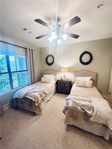 Well-lit sleeping quarters with plush carpet flooring and ample natural light.