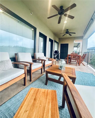 An inviting covered balcony offers plentiful space for relaxation and dining, complete with elegant outdoor furnishings.