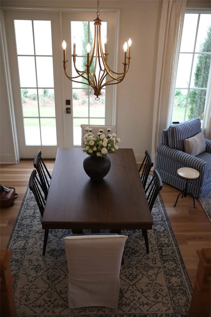 Warm wood flooring and classic French doors elevate this inviting dining space.