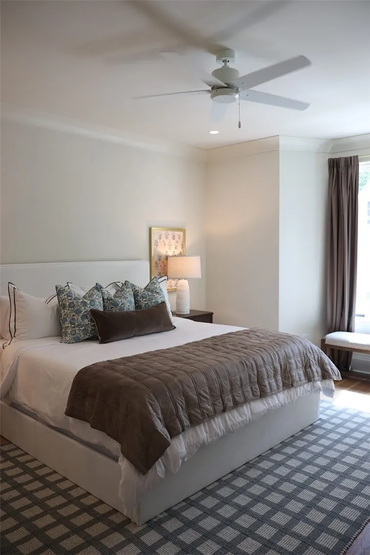 Smooth crown molding and warm wood floors anchor this comfortable primary bedroom suite.
