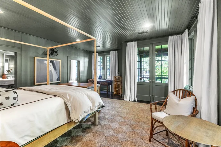 A well-lit primary bedroom offers direct access to the outdoors, promoting a serene retreat.