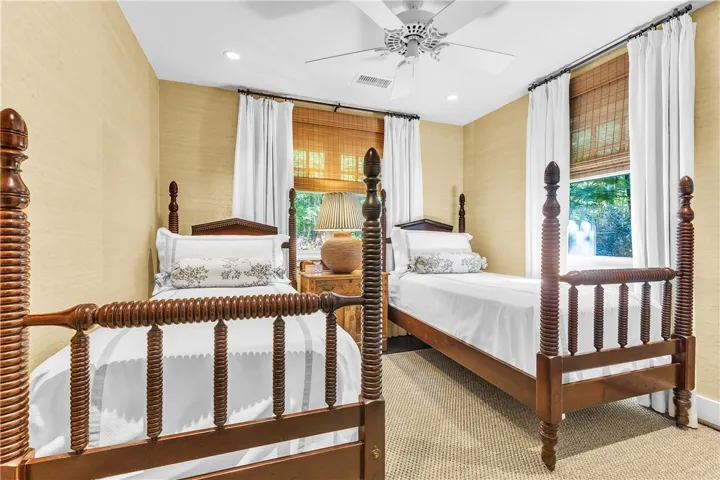 A comforting bedroom features woven wall coverings and robust wooden beds, inviting serene slumber.
