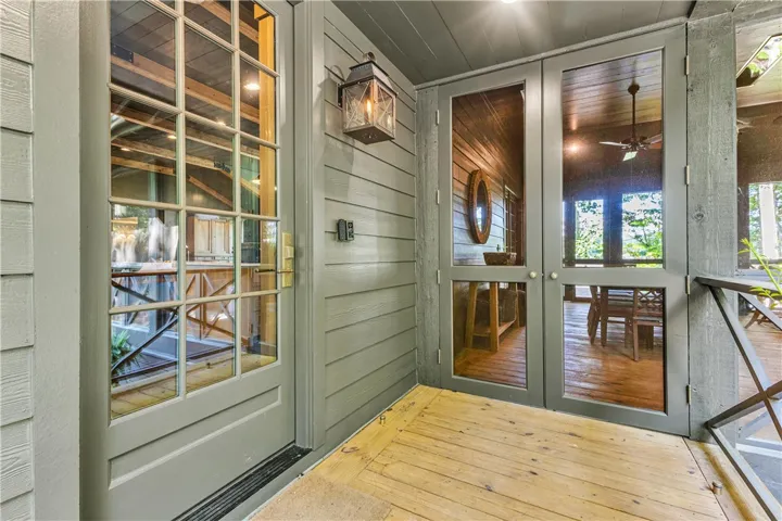 Welcome guests to a charming home featuring a wooden deck entrance and exterior doors.