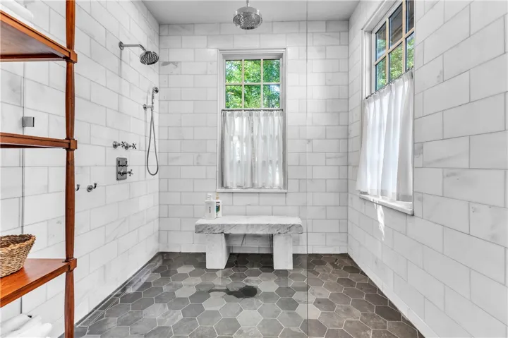 Luxurious walk-in shower featuring dual shower heads and hexagon tile flooring for a spa-like retreat.