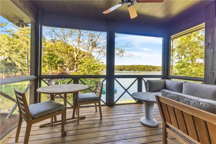 Enjoy tranquil lake views from this inviting screened porch, perfect for relaxation and entertaining.