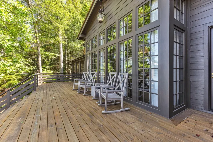 A spacious wooden deck provides ample outdoor living space, perfect for enjoying the serene wooded surroundings.