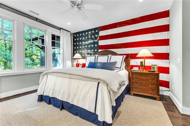 Well-lit sleeping quarters with a charming ceiling fan and natural hardwood floors.