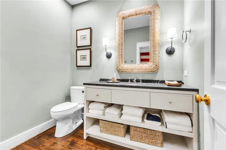 Stylish vanity with integrated storage and an ornate mirror creates a refined powder room.