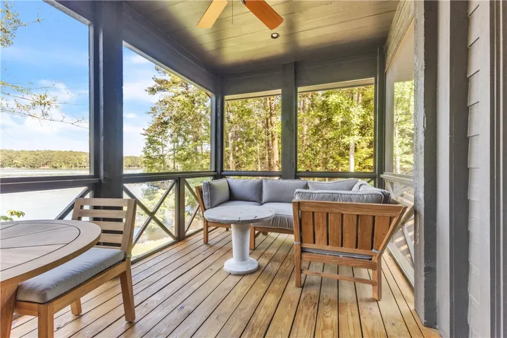 A spacious screened porch overlooks a tranquil lake, offering a perfect outdoor retreat.