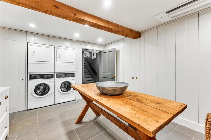 A utilitarian laundry space features exposed wood beams and functional appliances, offering practical living.