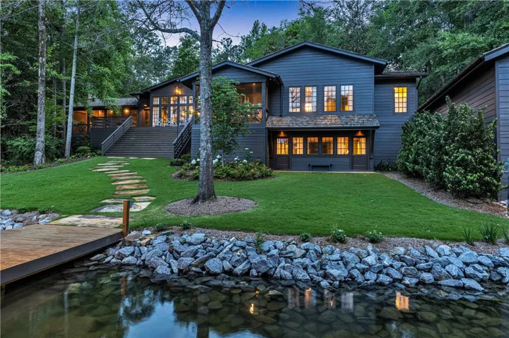 A tranquil lakeside retreat with lush green lawns and a private dock awaits.