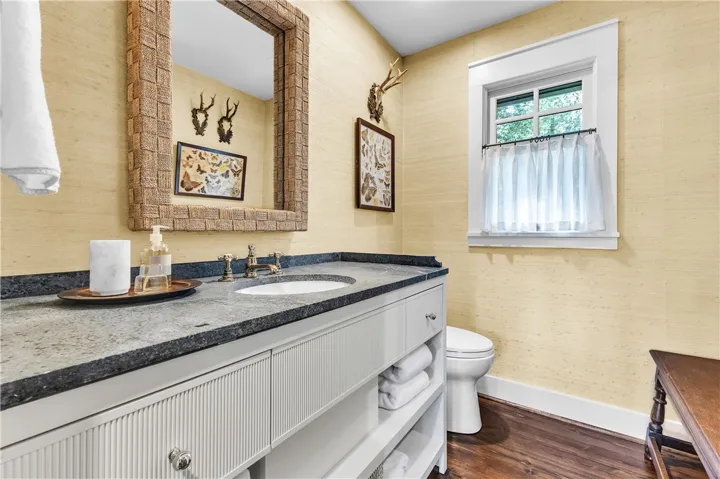 Elegant washroom with a textured vanity and dark stone countertop, perfectly illuminated by natural light.