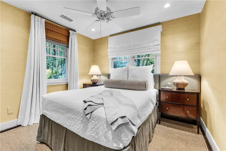 Natural light filters through ample windows into this comfortable and peaceful bedroom.