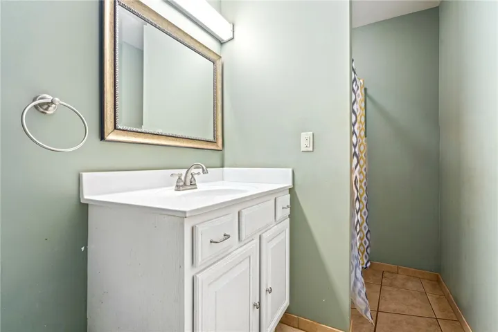 A functional bathroom with a crisp white vanity and a tiled shower area.