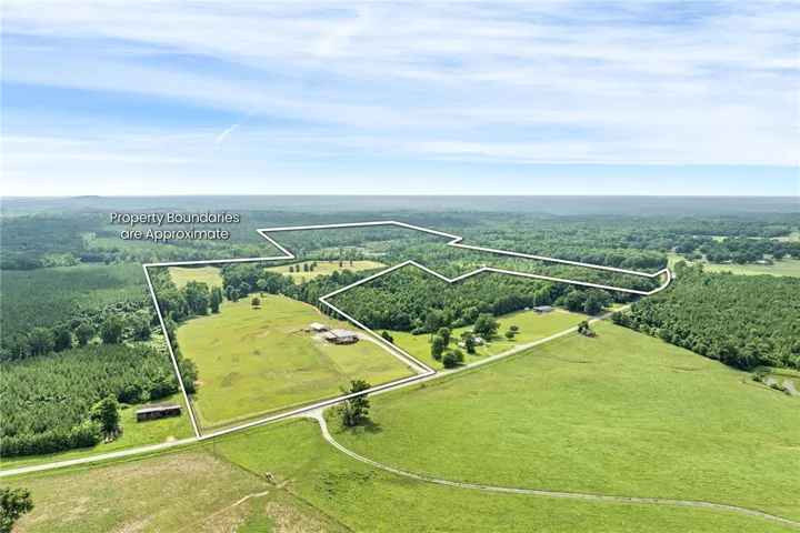 A vast expanse of undeveloped land offers a canvas for a dream estate, nestled amongst verdant fields and woodlands.