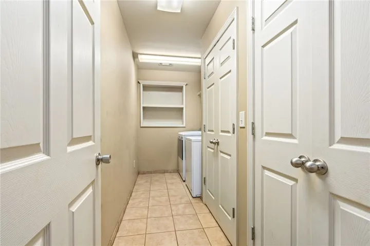 Functional utility space with durable tile flooring and convenient built-in shelving.