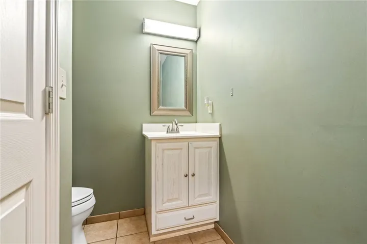 A compact half-bath presents a white vanity and framed mirror, ready for personalization.
